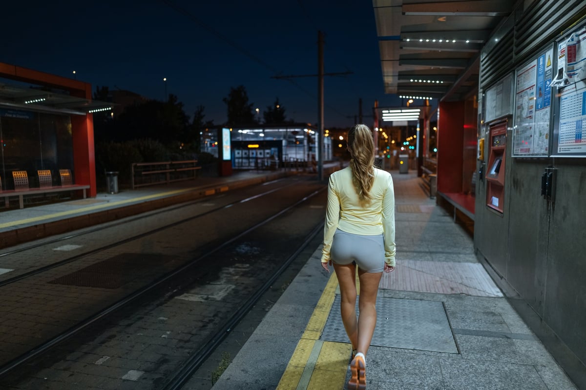 Runner in black technical gear on a night city platform